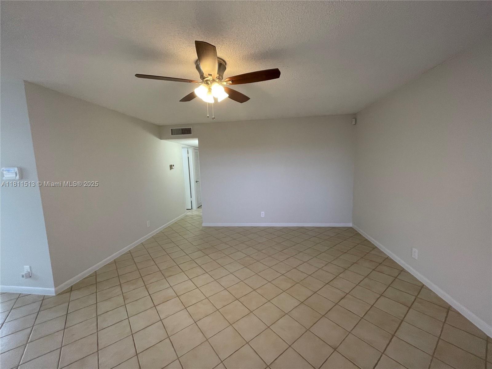413 Saxony Way, Unit 413 Delray Beach, FL 33446 - Photo 8 of 14 a view of an empty room and chandelier fan