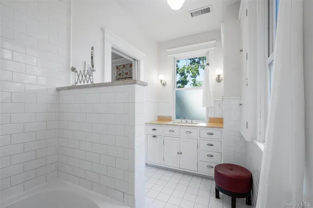 a bathroom with a bathtub sink and mirror