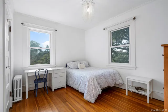 a bedroom with a bed wooden floor and a window