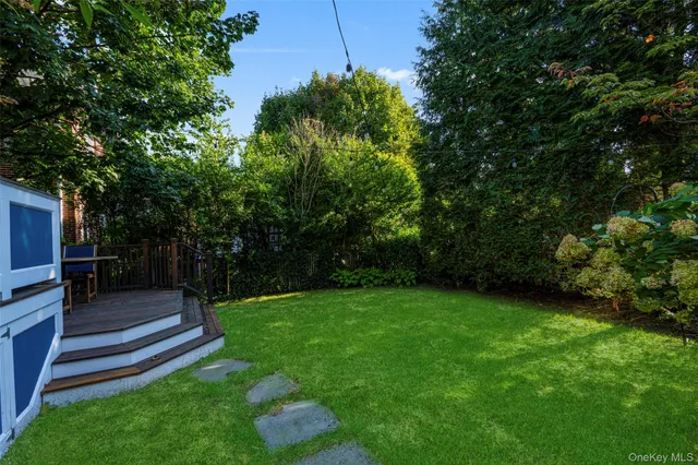 a view of a backyard with wooden fence and large trees