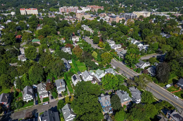 an aerial view of residential houses with outdoor space and trees