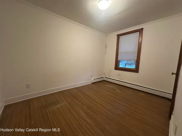 an empty room with wooden floor and closet area