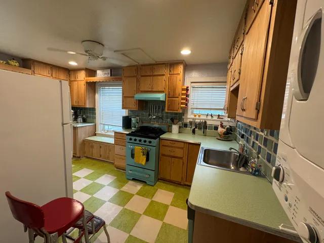 a kitchen with stainless steel appliances kitchen island granite countertop a sink and a refrigerator