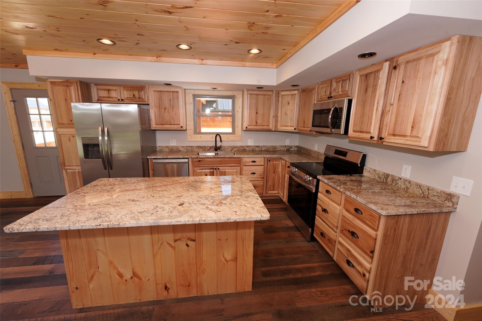 54 Alex Ridge Maggie Valley, NC 28751 - Photo 15 of 35 a kitchen with stainless steel appliances granite countertop wooden cabinets a sink a stove a washer and dryer
