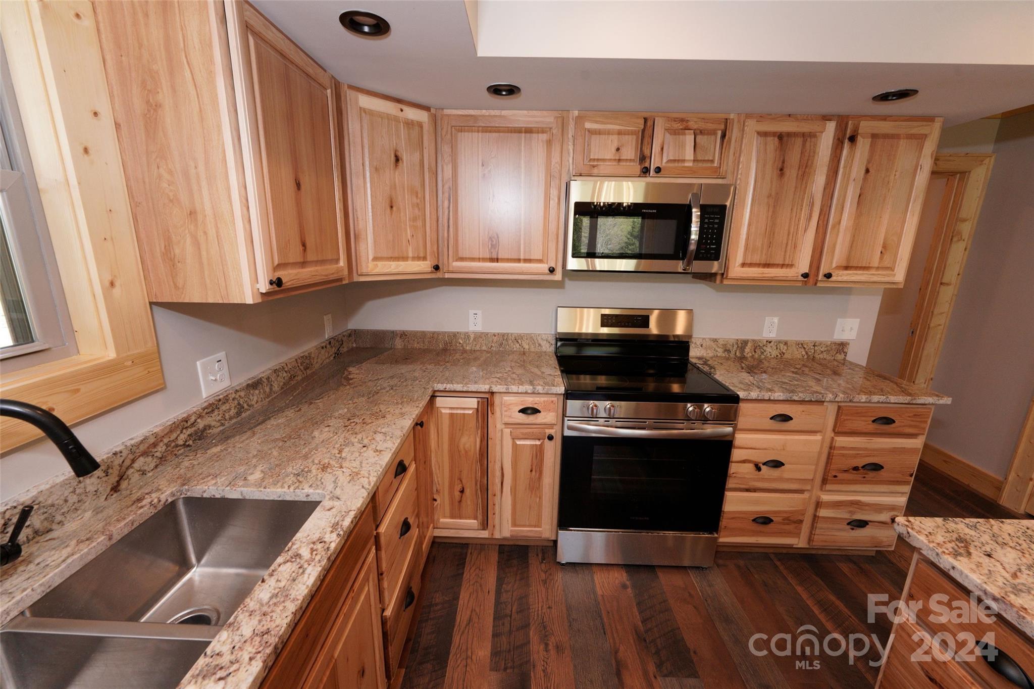 54 Alex Ridge Maggie Valley, NC 28751 - Photo 16 of 35 a kitchen with granite countertop a stove and a sink