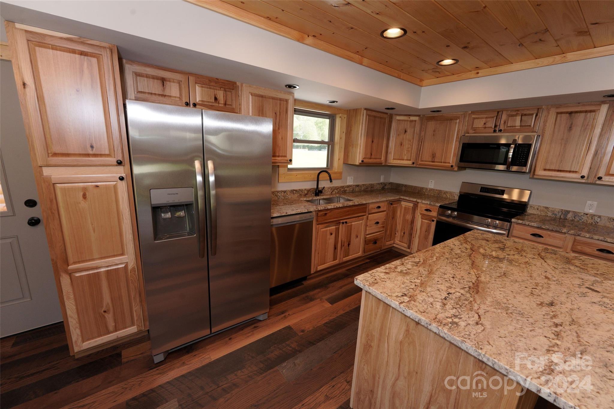 54 Alex Ridge Maggie Valley, NC 28751 - Photo 17 of 35 a kitchen with stainless steel appliances granite countertop a refrigerator a sink and wooden cabinets