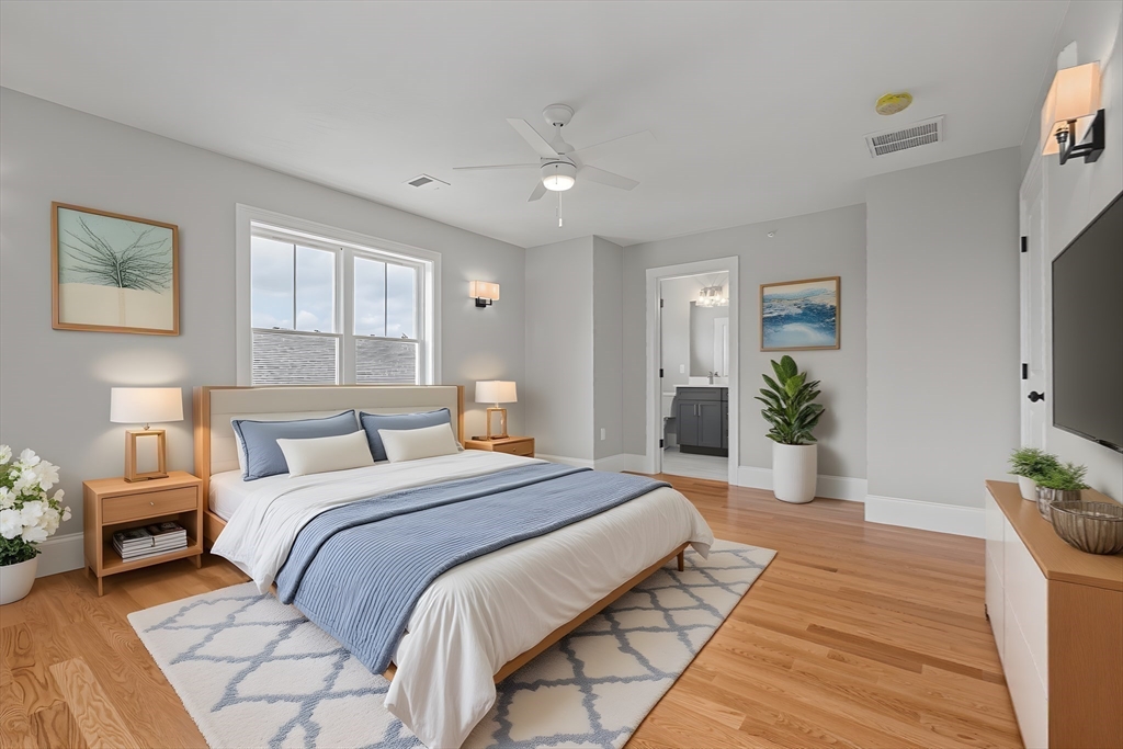 22 Pleasant Street, Unit B Mansfield, MA 02048 - Photo 18 of 26 a spacious bedroom with a large bed and a potted plant