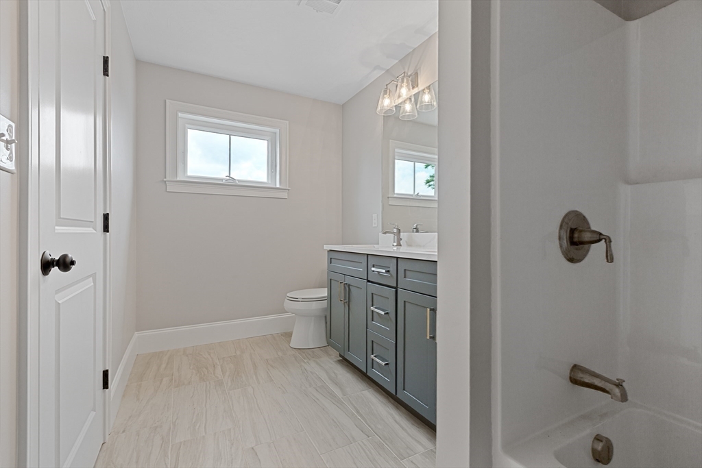22 Pleasant Street, Unit B Mansfield, MA 02048 - Photo 20 of 26 a bathroom with a granite countertop sink a toilet and shower