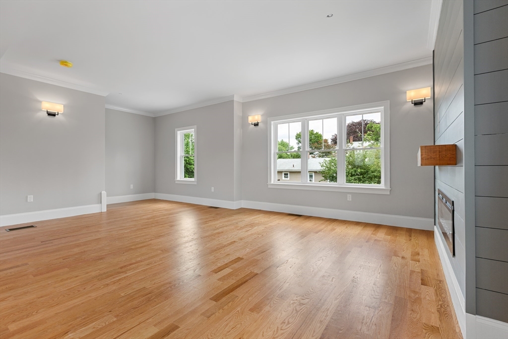22 Pleasant Street, Unit B Mansfield, MA 02048 - Photo 2 of 26 an empty room with wooden floor and windows