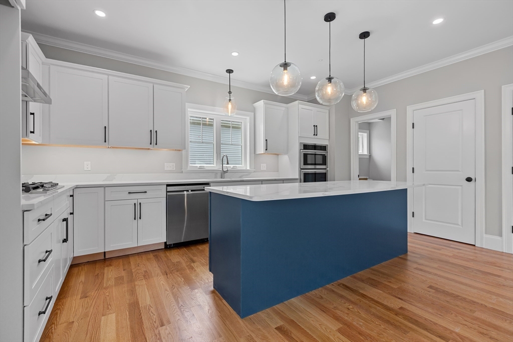 22 Pleasant Street, Unit B Mansfield, MA 02048 - Photo 3 of 26 a open kitchen with wooden floor and stainless steel appliances