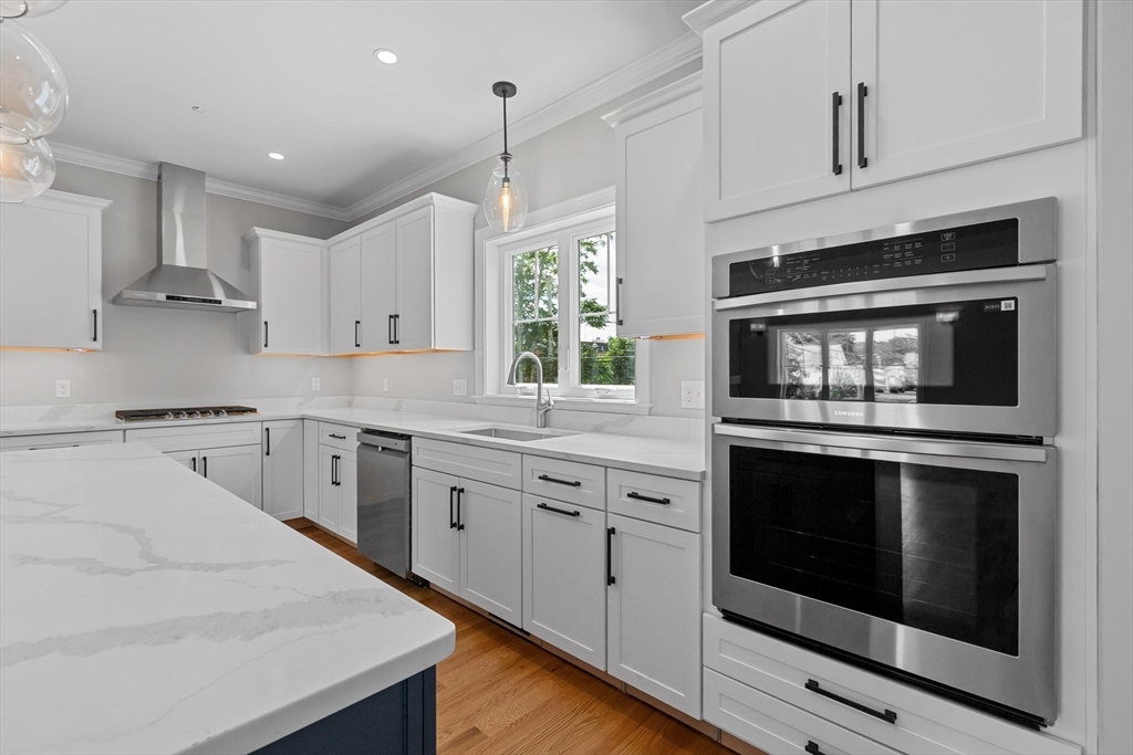 22 Pleasant Street, Unit B Mansfield, MA 02048 - Photo 5 of 26 a kitchen with granite countertop white cabinets stainless steel appliances and sink