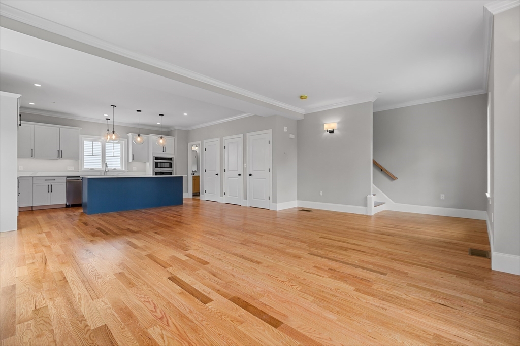22 Pleasant Street, Unit B Mansfield, MA 02048 - Photo 8 of 26 a view of kitchen and empty room with wooden floor