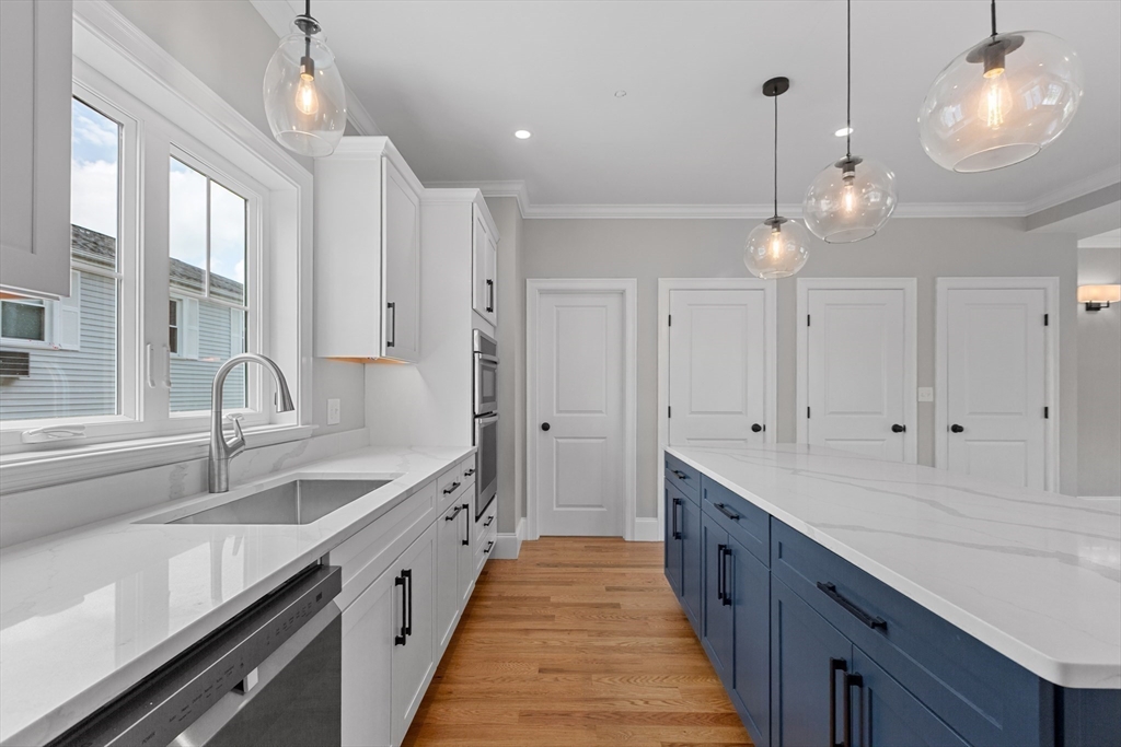 22 Pleasant Street, Unit B Mansfield, MA 02048 - Photo 9 of 26 a large kitchen with kitchen island white cabinets and appliances