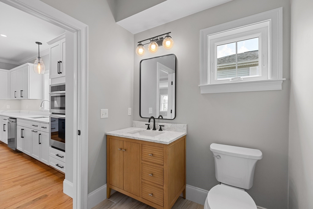 22 Pleasant Street, Unit B Mansfield, MA 02048 - Photo 10 of 26 a bathroom with a toilet sink and mirror