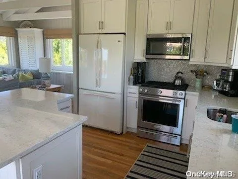 a kitchen with stainless steel appliances a stove a microwave and a sink