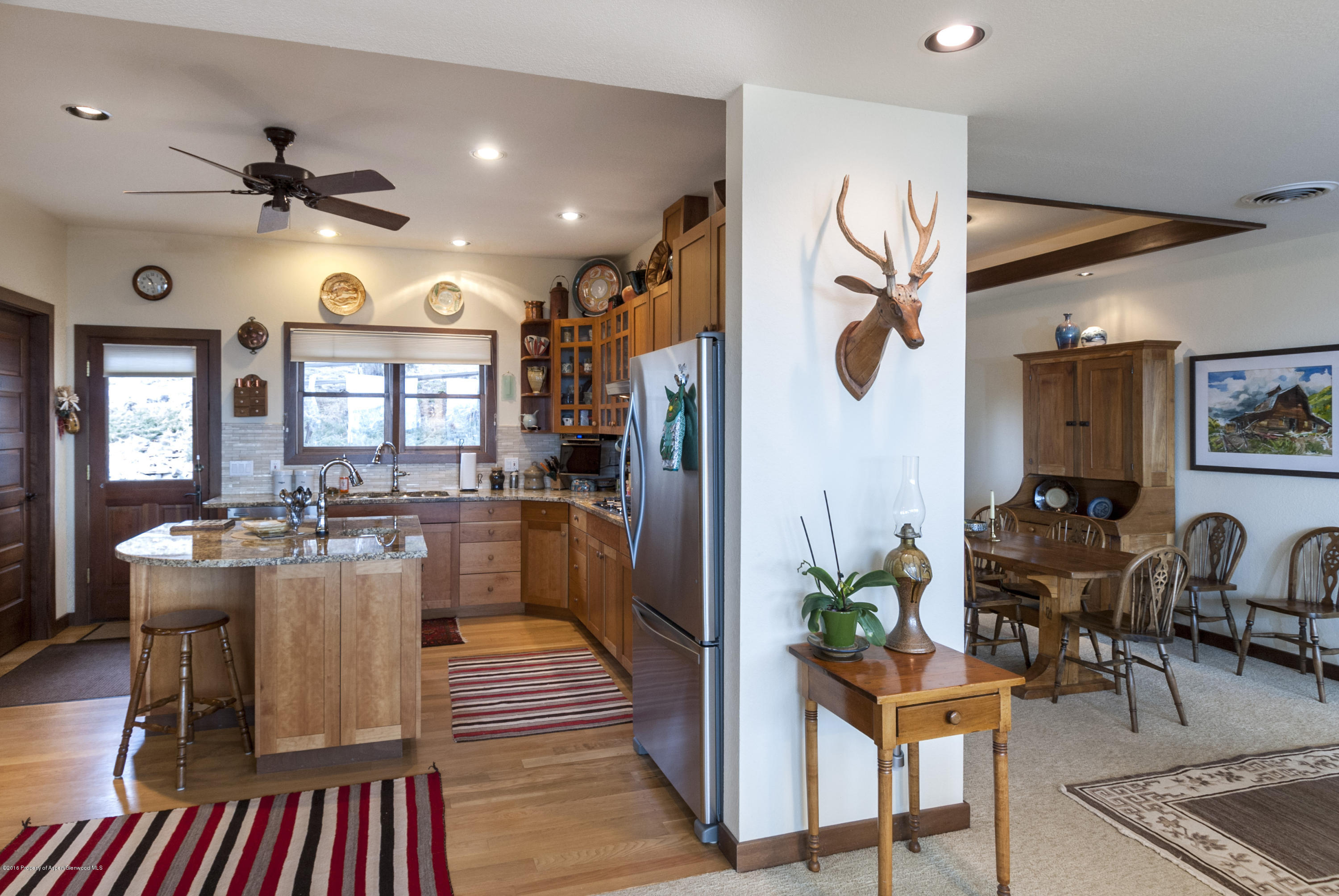 550 Wooden Deer Road Carbondale, CO 81623 - Photo 7 of 21 a kitchen with stainless steel appliances granite countertop dining table chairs and white cabinets