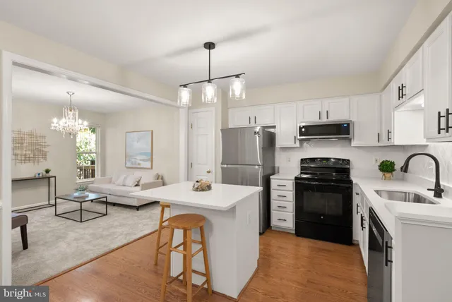a kitchen with stainless steel appliances kitchen island granite countertop a sink refrigerator and cabinets