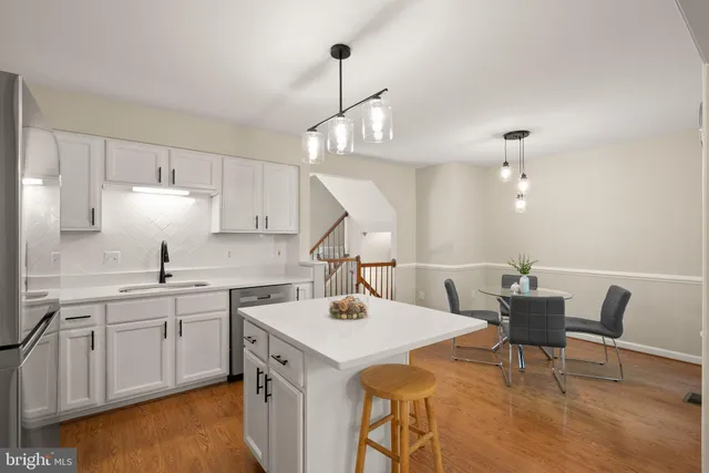 a kitchen with a sink a cabinets and chairs
