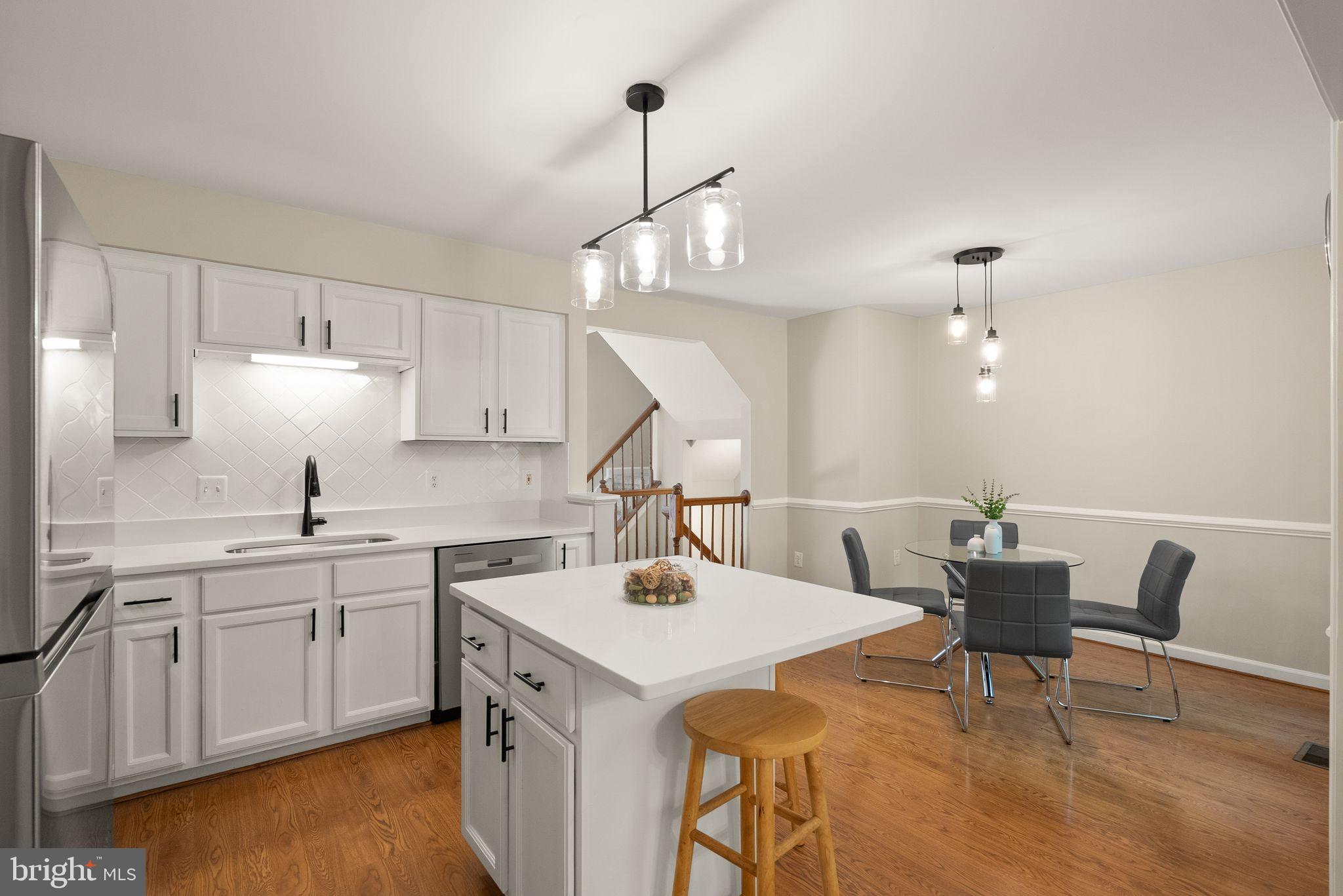 20544 Morningside Terrace Sterling, VA 20165 - Photo 14 of 54 a kitchen with a sink a cabinets and chairs
