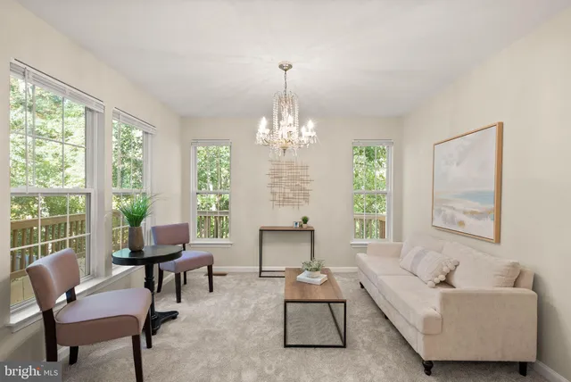 a living room with furniture and a chandelier