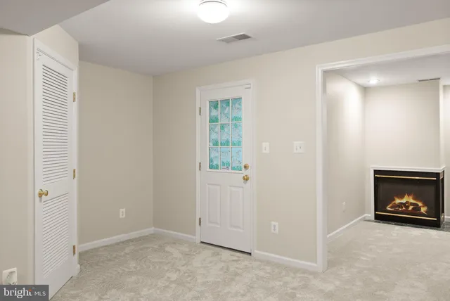 a view of an empty room with fire place and a window