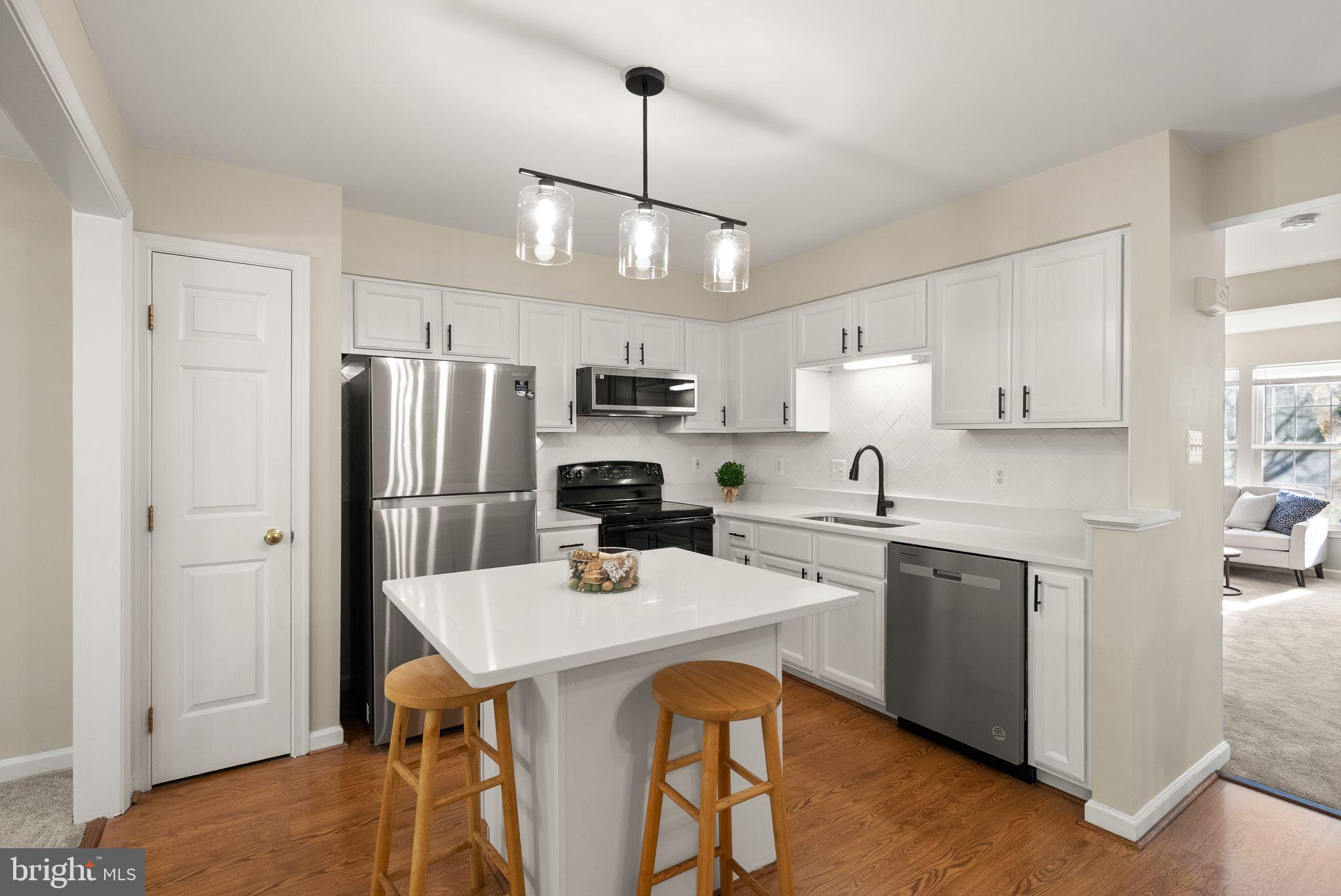 20544 Morningside Terrace Sterling, VA 20165 - Photo 9 of 54 a kitchen with stainless steel appliances a dining table a sink a stove and refrigerator