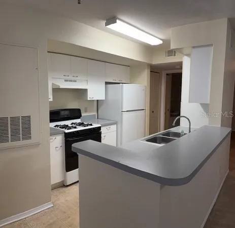 a kitchen with kitchen island a counter and a refrigerator
