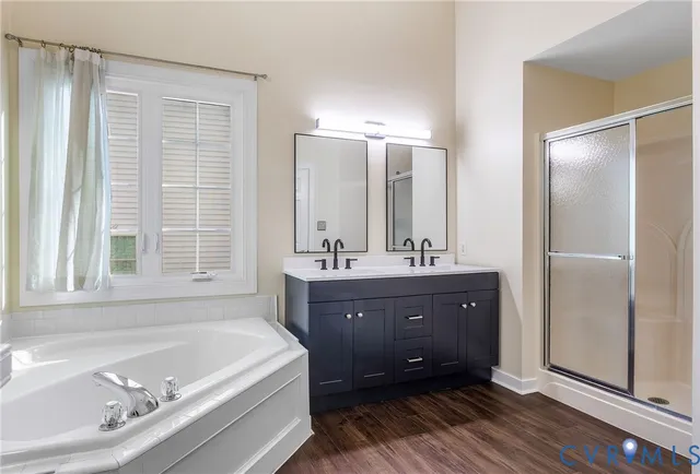 a bathroom with a tub sink double vanity granite and a mirror