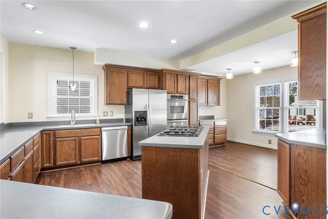 a view of a kitchen with wooden floor and stainless steel appliances