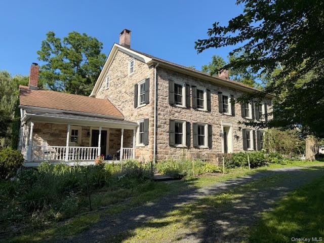 510 Decker Road Wallkill, NY 12589 - Photo 2 of 4 Beautiful home with shutters featuring covered porch, stone siding, and a chimney