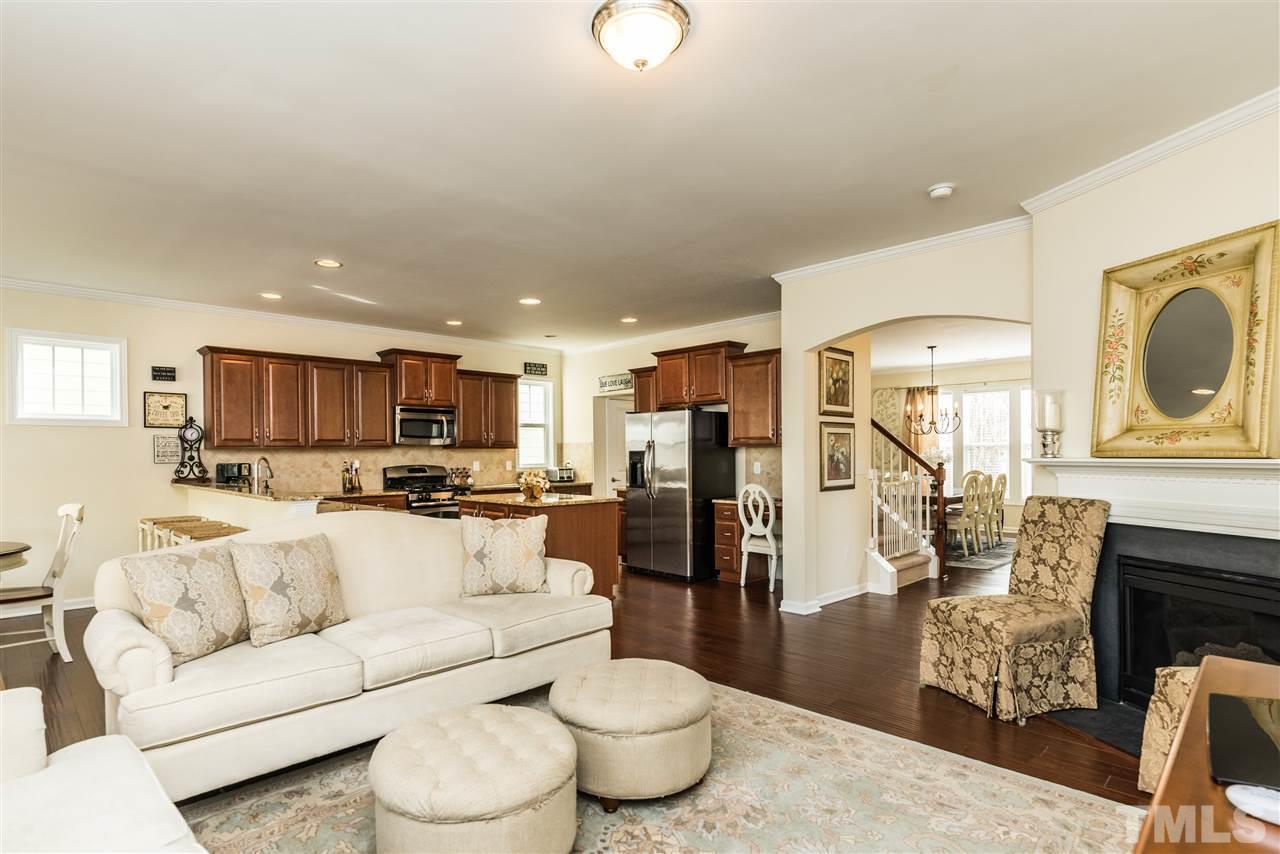 1413 Van Page Boulevard Raleigh, NC 27607 - Photo 11 of 25 a living room with furniture a fireplace and a kitchen view