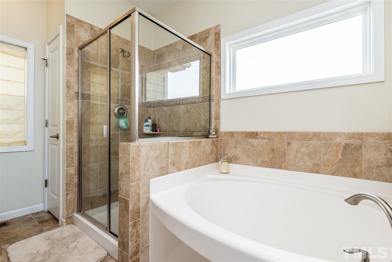 1413 Van Page Boulevard Raleigh, NC 27607 - Photo 15 of 25 a bathroom with a bathtub and a shower
