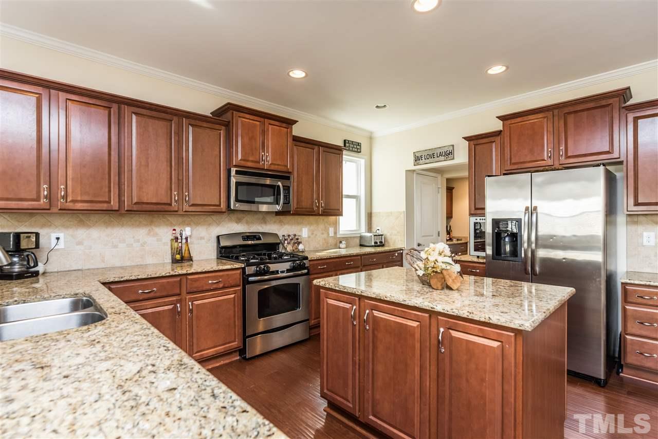 1413 Van Page Boulevard Raleigh, NC 27607 - Photo 6 of 25 a kitchen with stainless steel appliances granite countertop a sink stove refrigerator and cabinets
