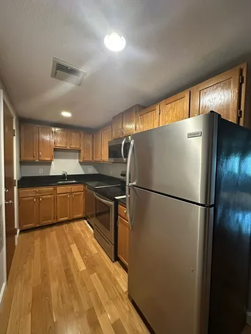 a kitchen with a refrigerator a sink and a stove top oven