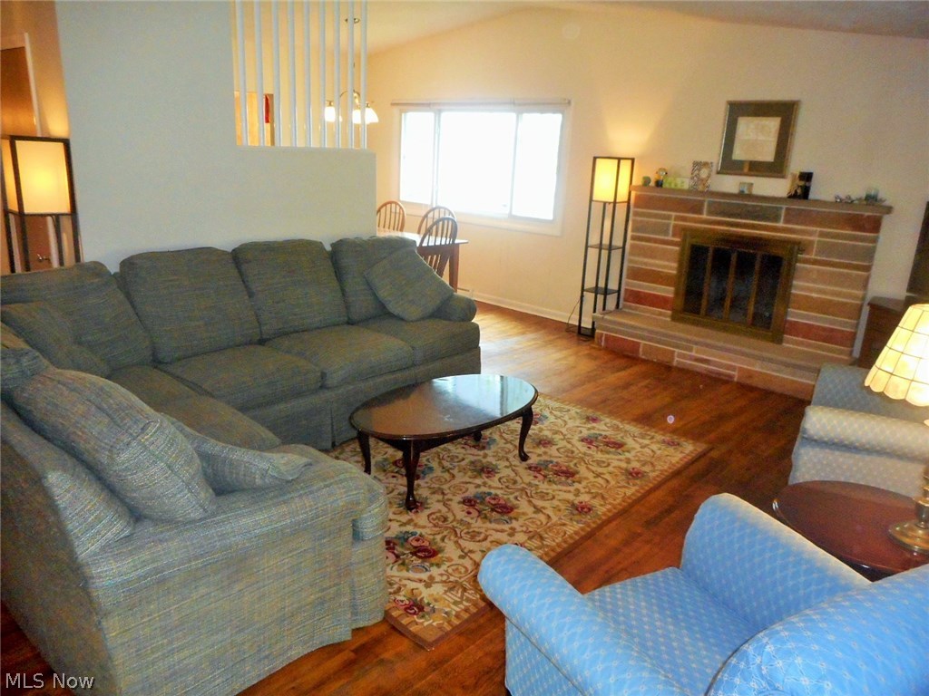 658 Garnette Road Akron, OH 44313 - Photo 8 of 24 The living room, with vaulted ceiling, wood flooring; a stone, wood burning fireplace, and picture window facing the backyard..