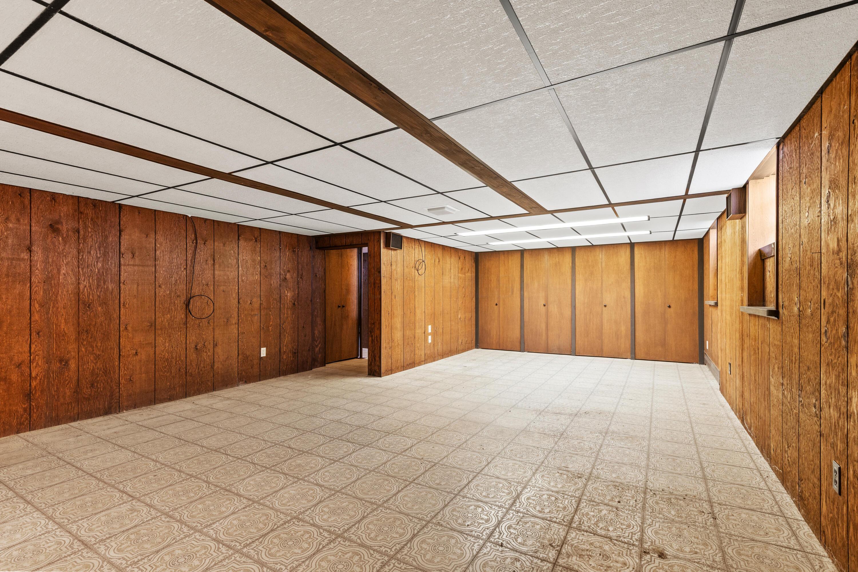 6982 Lee Road Westerville, OH 43081 - Photo 50 of 71 • Neutral vinyl flooring • Paneled walls • Acoustic ceiling tiles with fluorescent lighting • Can lighting • Woodburning, brick fireplace • Baseboard heat • (2) glass block windows • Built-in book shelves • Full wall of closets (cedar lined)
