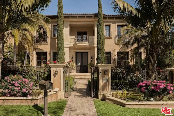 a front view of a house with a garden and plants