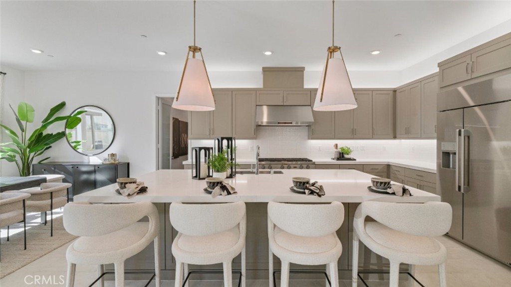 a kitchen with stainless steel appliances a dining table chairs and white cabinets