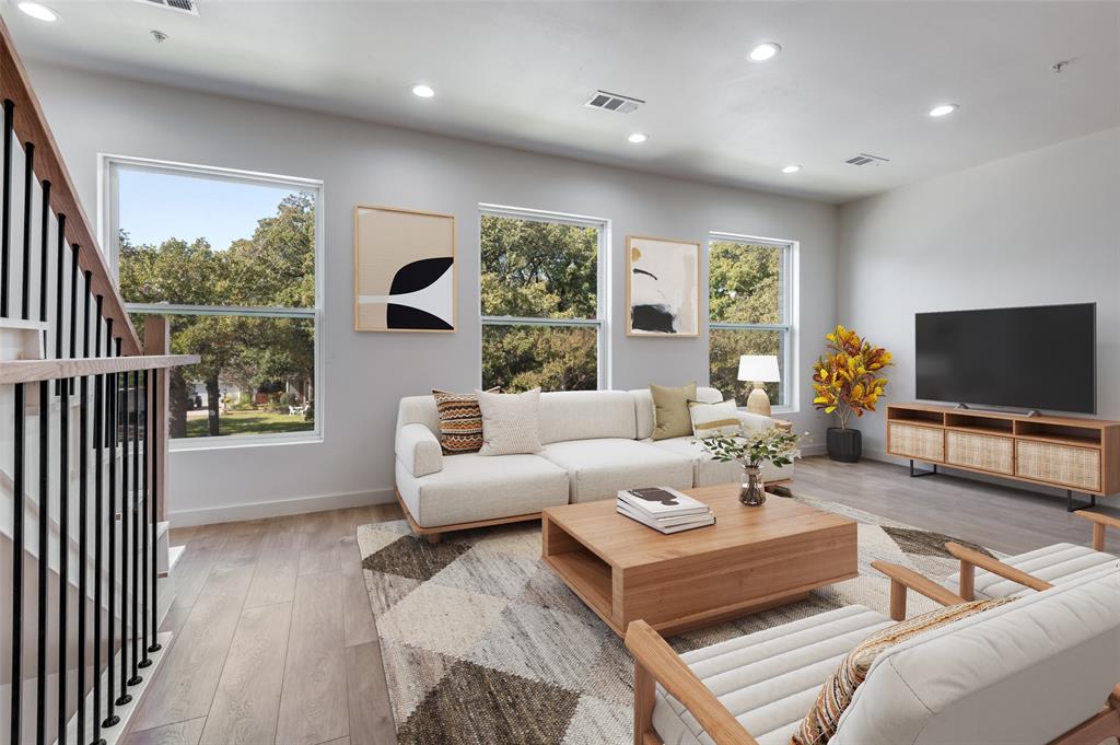a living room with furniture a flat screen tv and a large window