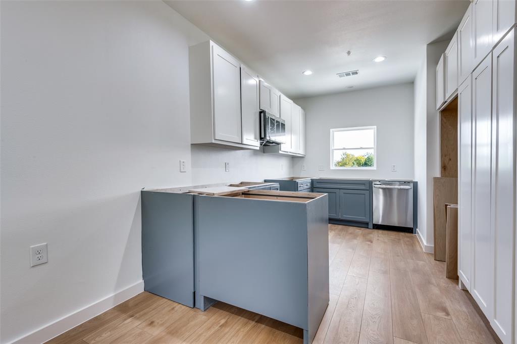 516 South O Connor Road Irving, TX 75060 - Photo 28 of 40 a kitchen with wooden cabinets and white appliances