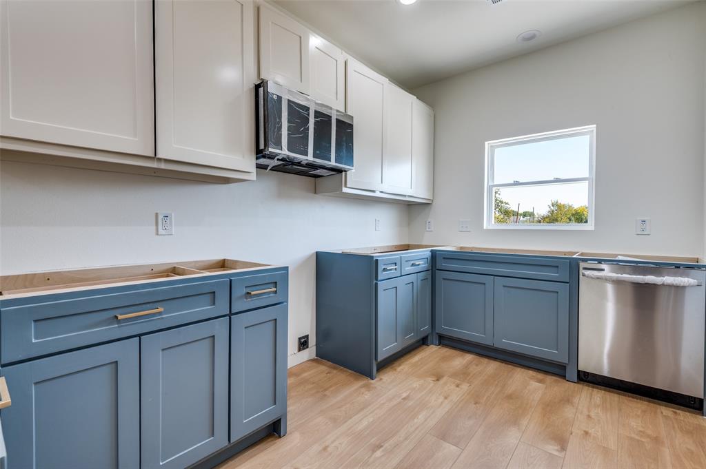 516 South O Connor Road Irving, TX 75060 - Photo 29 of 40 a kitchen with stainless steel appliances granite countertop a stove a microwave and white cabinets
