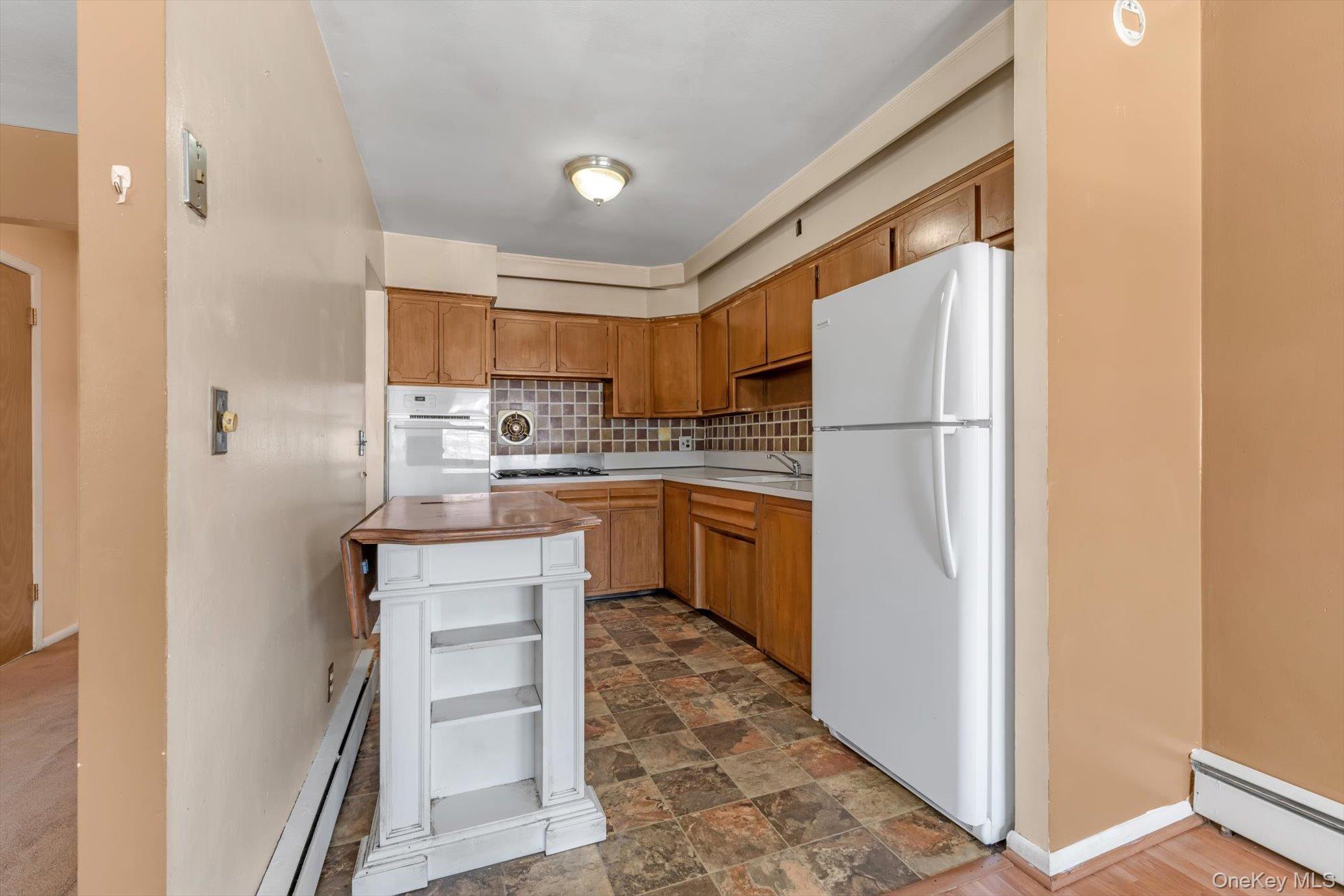 144-64 25th Road Queens, NY 11354 - Photo 5 of 21 a kitchen with a refrigerator a sink and a stove