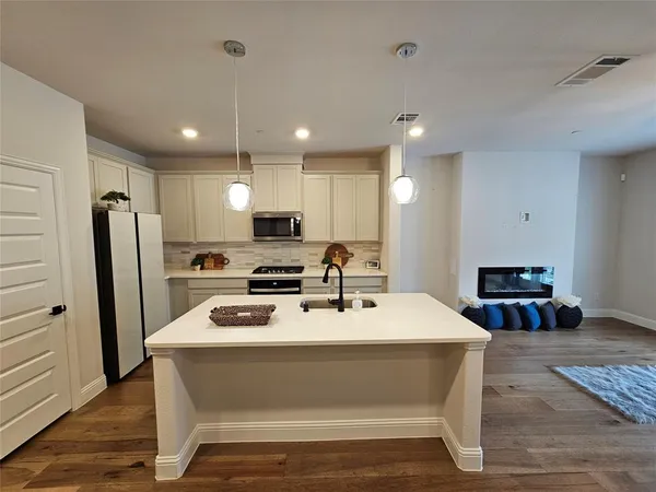 a large white kitchen with refrigerator stove and a sink