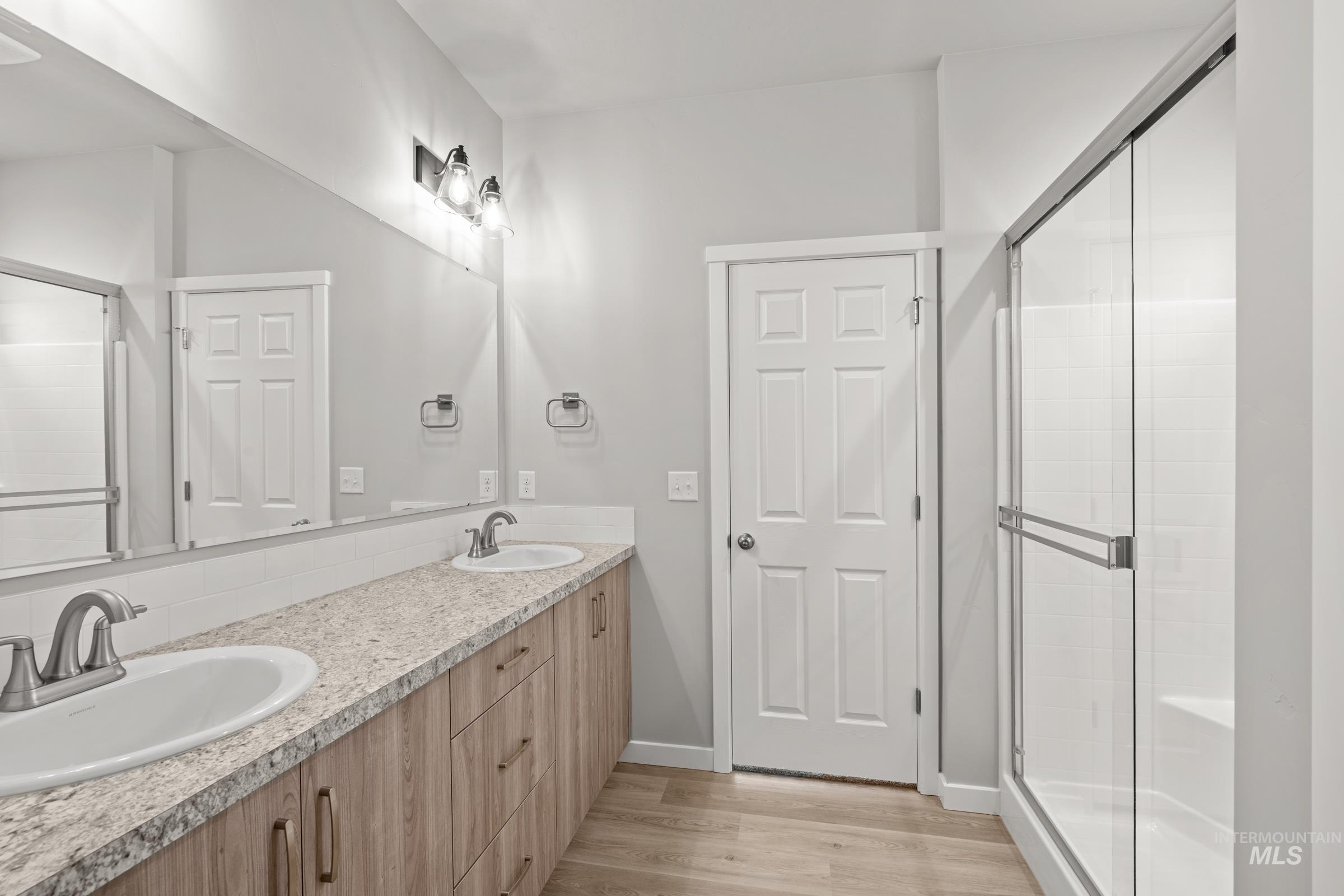 487 Hamlow Avenue Middleton, ID 83644 - Photo 13 of 19 Bathroom with double vanity, a stall shower, and light wood-type flooring