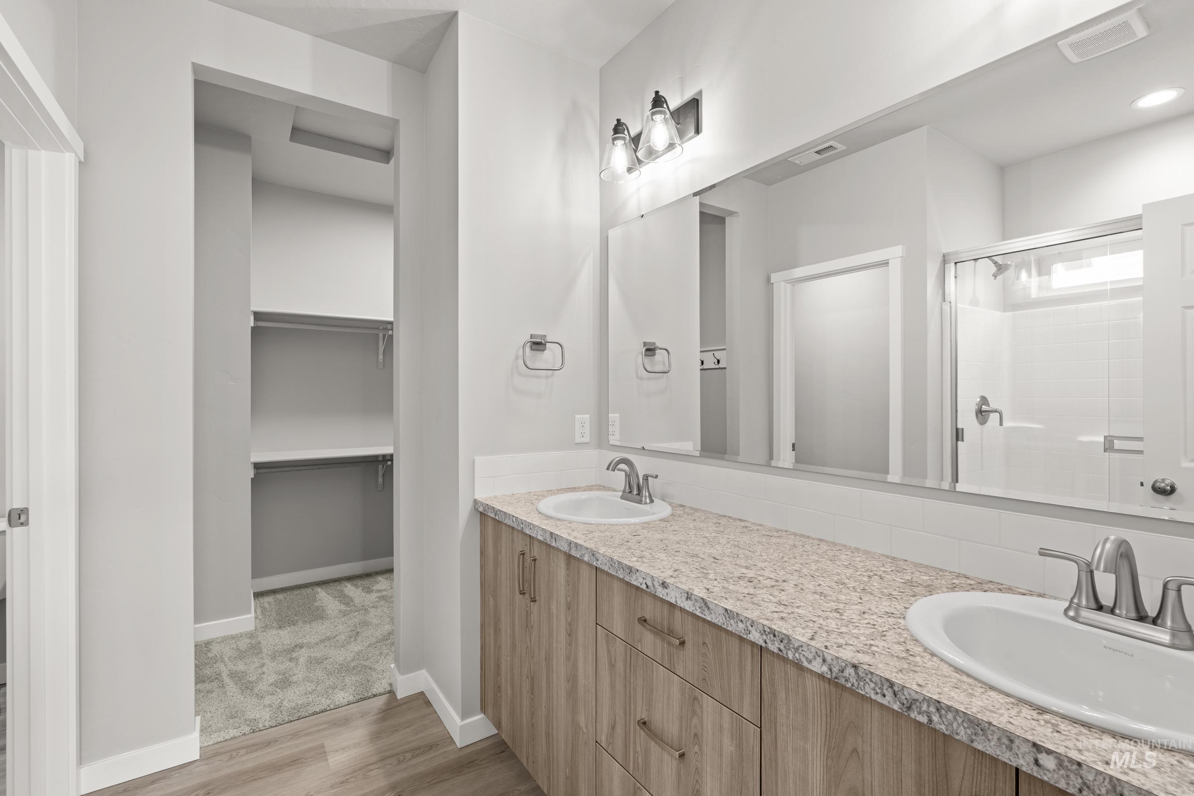 487 Hamlow Avenue Middleton, ID 83644 - Photo 14 of 19 Full bathroom featuring double vanity, a stall shower, light wood-style floors, and a spacious closet