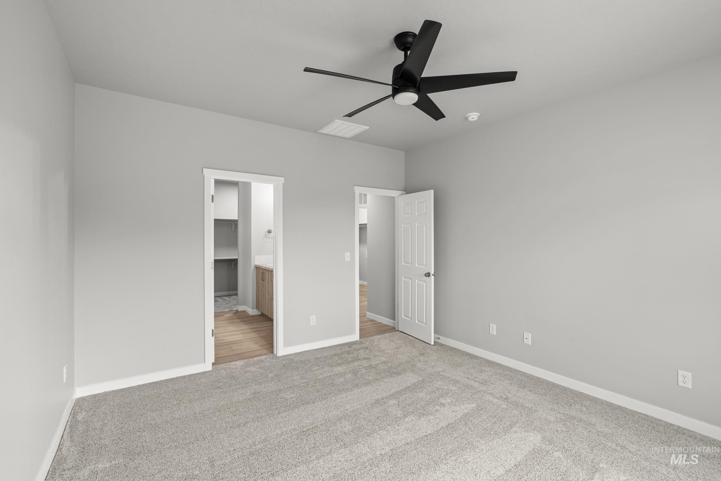 487 Hamlow Avenue Middleton, ID 83644 - Photo 16 of 19 Unfurnished bedroom with ensuite bathroom, light colored carpet, a ceiling fan, and a spacious closet