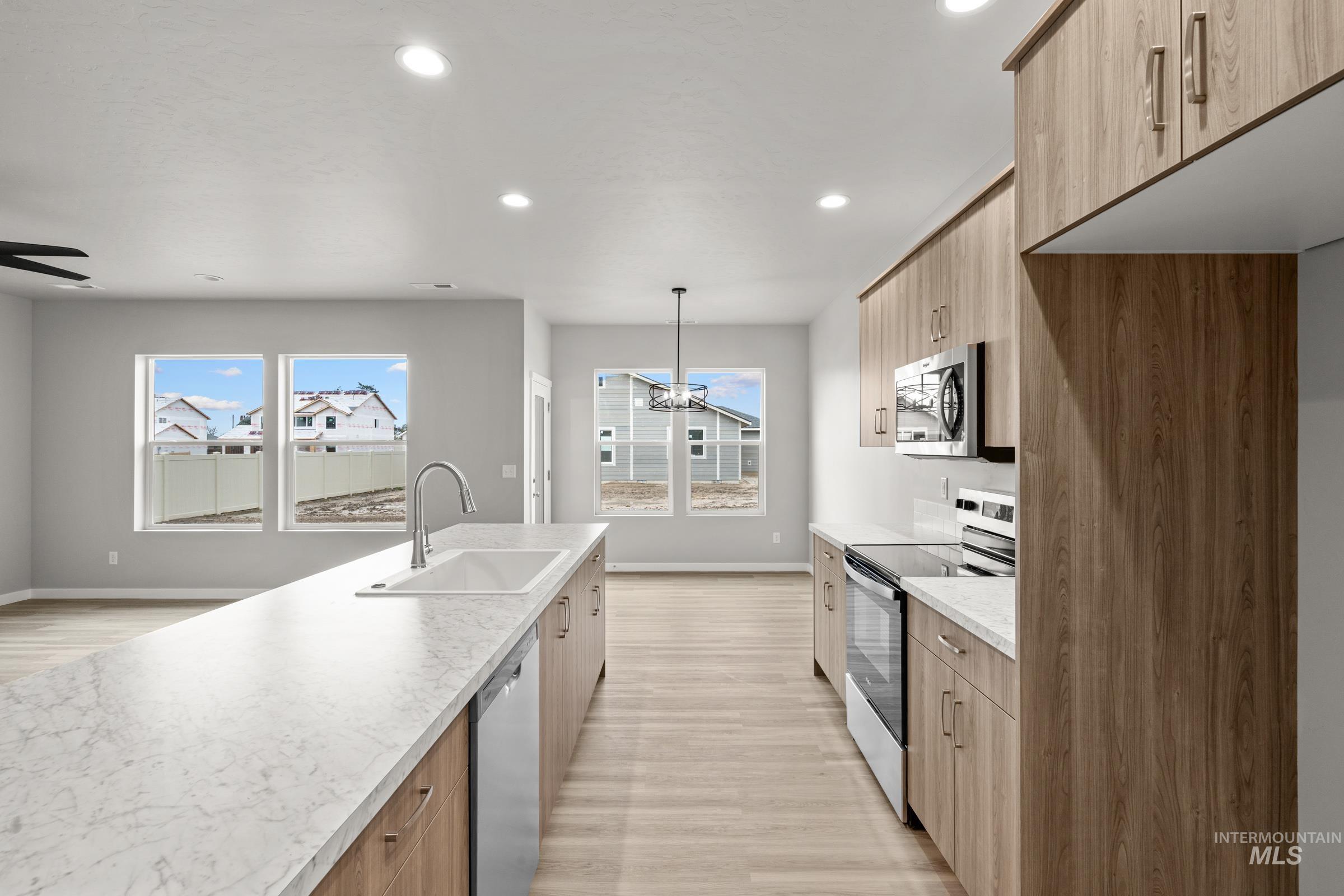 487 Hamlow Avenue Middleton, ID 83644 - Photo 4 of 19 Dual tone kitchen featuring stainless steel appliances, light wood-style floors, modern cabinets, two tone cabinets, and hanging lights