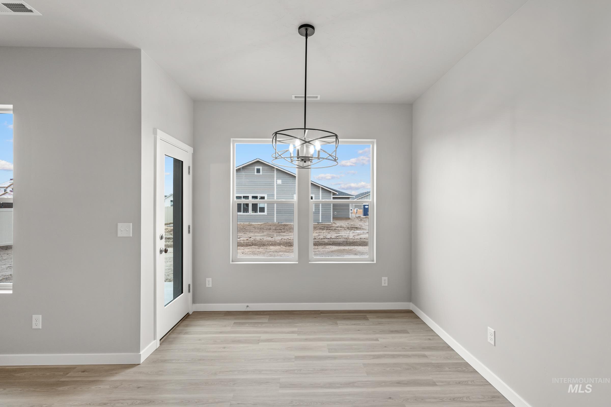 487 Hamlow Avenue Middleton, ID 83644 - Photo 6 of 19 Unfurnished dining area featuring light wood-type flooring and hanging lights