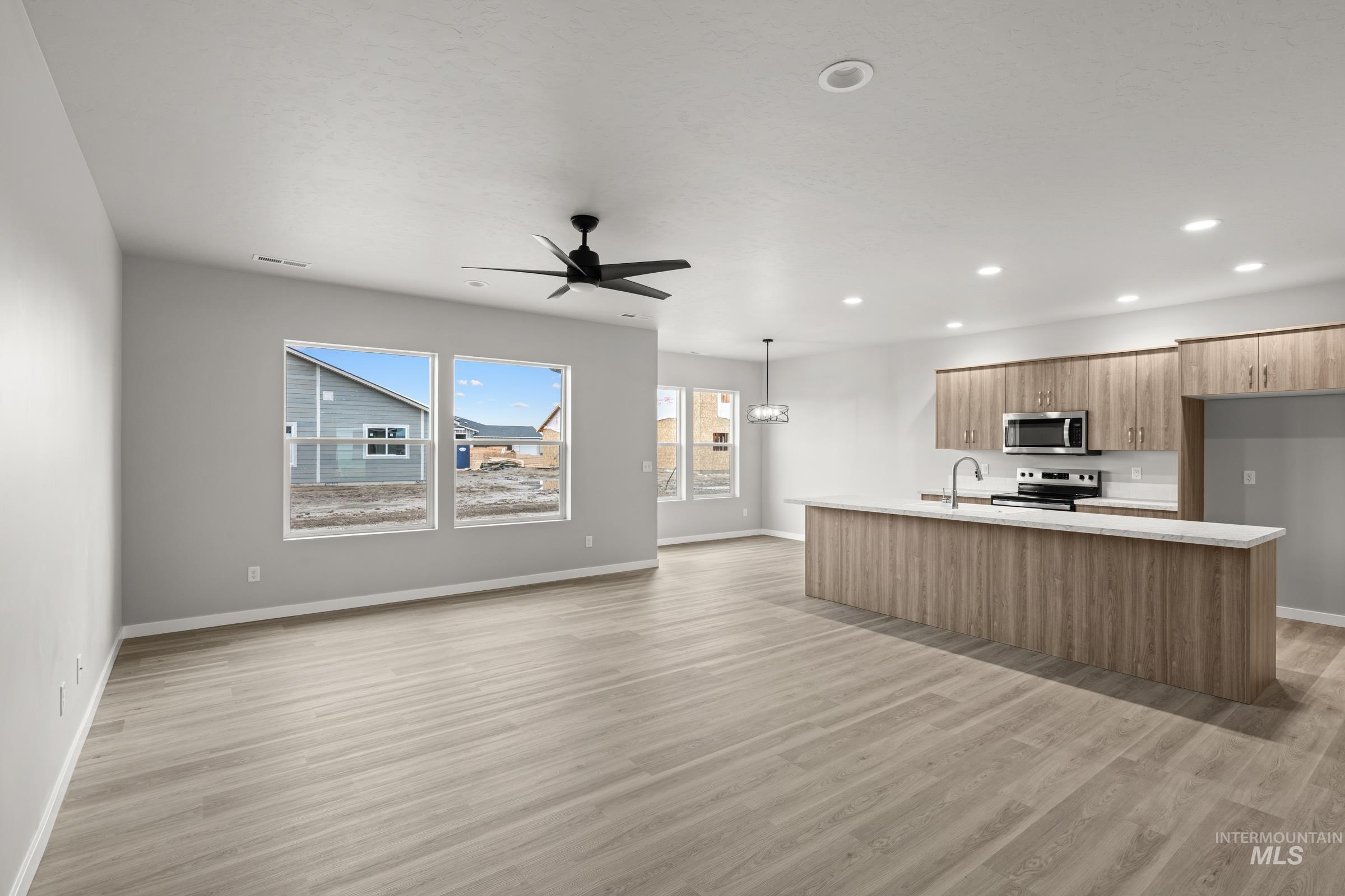 487 Hamlow Avenue Middleton, ID 83644 - Photo 19 of 19 Kitchen featuring an island with sink, stainless steel appliances, modern cabinets, open floor plan, and light wood-style flooring