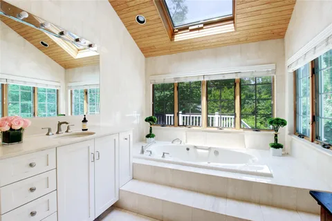 a bathroom with a tub sink and large window